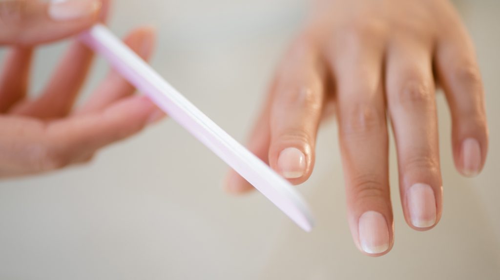 Close up of Hispanic woman filing her nails